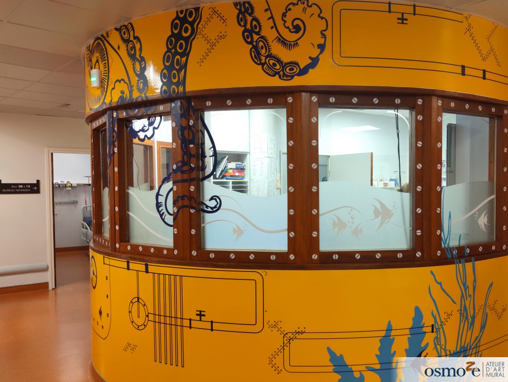 Animation de l'espace central du service pédiatrie avec une décoration qui se déploie sur les murs et les vitres - design qui appelle un sous-marin explorant les profondeurs de l'océan